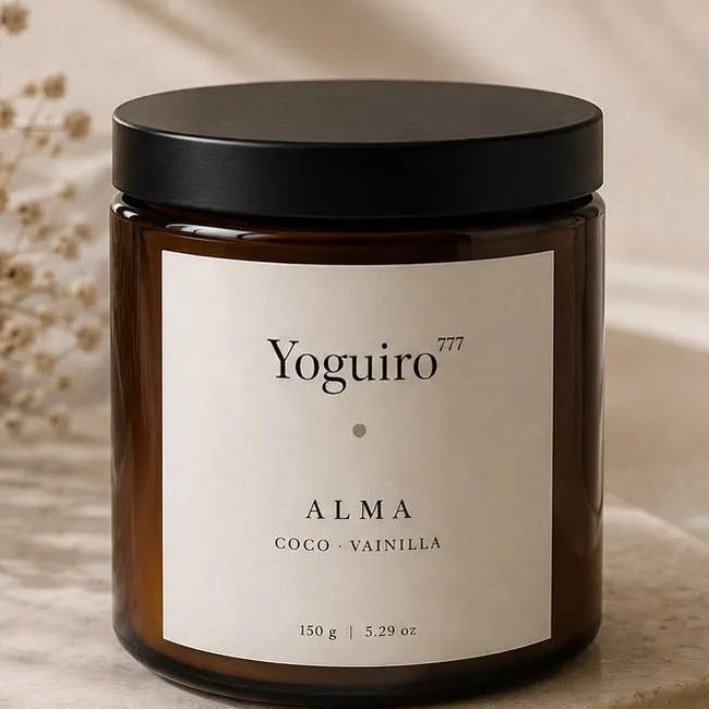 Vela Alma de Yoguiro777 en frasco ámbar, junto a su caja y una rama seca